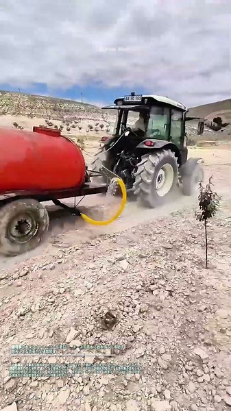 農用車で水タンクトレーラーを牽引し、ホースで苗木に散水する：移動式散水による効率的な植栽管理