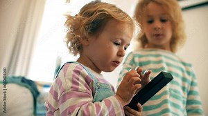 Little sisters watch television and use TV remote at home together Stock-Video
