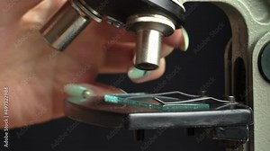 Microscope glass and magnifying glass rise close up. The study of the structure of molecules. Magnifying glass and the scientist looks with one eye. Biologist, researcher.