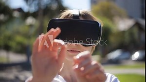 woman getting experience using virtual reality glasses VR headset outside 3d cyberspace gesturing full face hands gentle moving touching object closeup nice unfocused smiling smile girl portrait sunny