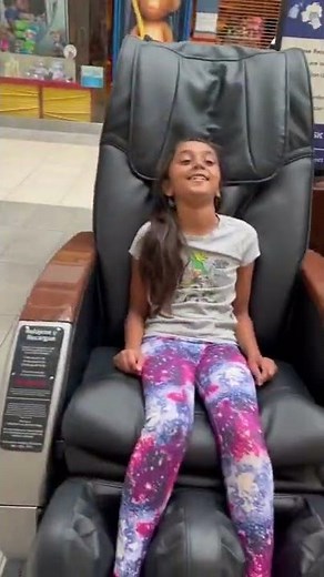 Little girl sitting in massage chair