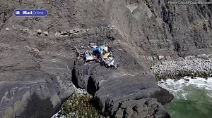 Drone footage shows driftwood home perched on cliff