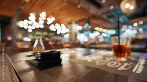 Close-up elegant restaurant table setup featuring a soy sauce bottle, chopsticks, and dishes with soft bokeh lights in blurred background. Warm ambiance enhances dining experience with cozy, inviting