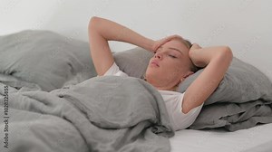 Uncomfortable Young Woman Having Nightmare while Sleeping in Bed