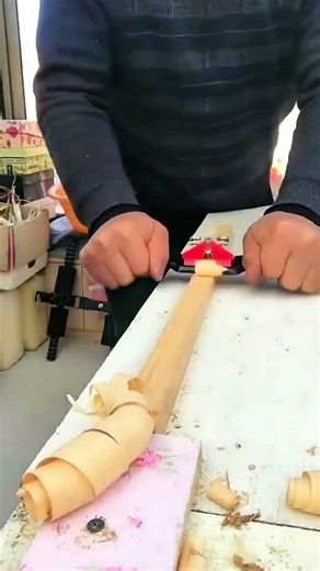 Shaping a round wooden pole with a sharp spokeshave tool for a professional smooth finish