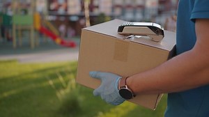 postman or delivery man carry small box deliver to customer at home contactless nfc terminal payment.