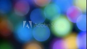 Fast moving repetitious multicoloured out of focus round blurry bokeh background constantly twirling