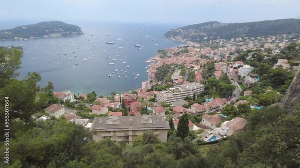 panning shot from high elevation villefranche-sur-mer town’s architecture surrounded by lush green cover built natural landscapes hilltop town architecture panning shot french riviera scenic view