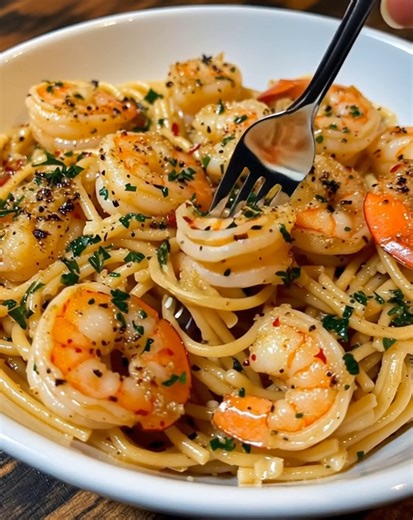 🍝 Garlic Butter Shrimp Pasta 🍤 A quick, irresistible weeknight comfort meal! 📝 Ingredients: 300g spaghetti 400g shrimp, peeled and deveined 3 tbsp butter 2 tbsp olive oil 4 garlic cloves, minced 1/2 tsp crushed red pepper flakes Salt and black pepper to taste Juice of 1/2 lemon 2 tbsp chopped parsley 1/4 cup grated Parmesan (optional) 🍴 How to prepare it: 1️⃣ Cook the pasta: Boil spaghetti in salted water until al dente — the foundation of a quick weeknight dinner. Drain and reserve 1/2 cup 