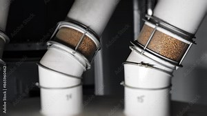 Grain supply pipes feeding automated flour milling system inside industrial plant.