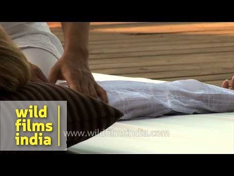 Woman gives massage therapies to a tourist at a resort in Goa