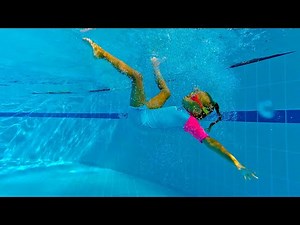 Funny Girl swims in the swimming pool with water slides and inflatable trampolines