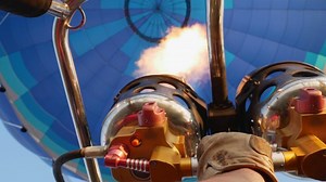 The pilot's arm includes gas equipment to fill the balloon dome with hot air.Bright burning flame inside the air balloon