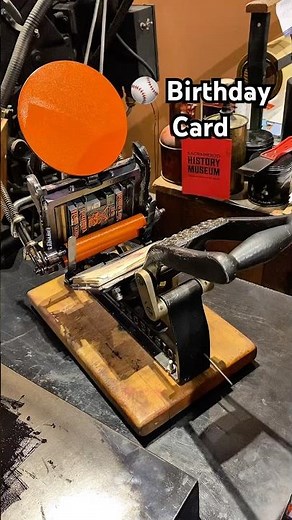 Printing some orange baseball birthday cards with a tabletop printing press