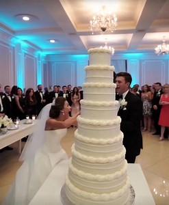 As I raised the knife to slice the wedding cake, my sister wrapped her arms around me, pulled me close, and breathed into my ear: “Knock it over. Now.” I froze. Her grip trembled. My eyes flicked from her pale face… to my groom’s wide smile. And before logic could catch up to instinct, I shoved the cake cart sideways. The entire towering masterpiece toppled in slow motion, exploding across the marble floor as guests shrieked. Gasps. Screams. A violinist dropped his bow. In the chaos, Sarah’s fin