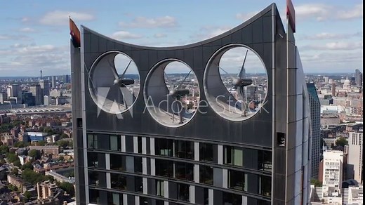 Close up footage of propellers of wind turbines integrated into skyscraper design. Ecology and sustainable energy resources. London, UK