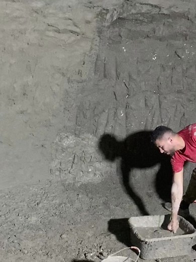 Construction Worker Applying Cement in Underground Chamber