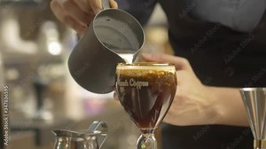 woman pouring cream on top of coffee drink - static