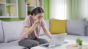 Nausea asian young woman. The young woman who feels sick at home runs to the sink and vomits.