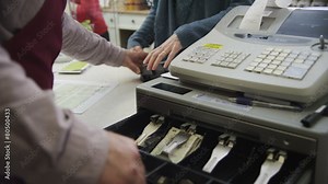 Shopkeeper takes a credit card payment from a cheerful female customer