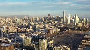 Aerial view of San Francisco, California downtown skyline cityscape landscape with industrial warehouses during morning sunrise - 4K Drone