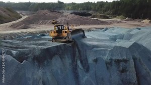 Big yellow excavator working in gravel quarry. Stock footage. Professional Mining industry concept, large construction excavator of yellow color at the construction site located in the industrial zone