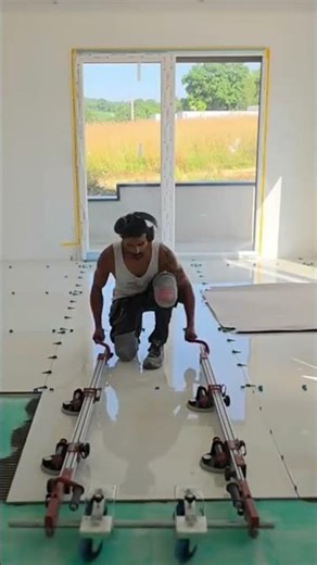 installing large white ceramic tiles on the floor in a room in the house with the help of tools