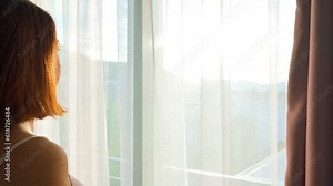 Woman opening curtains at home, The new day begins concept. 4k video footage in slow motion