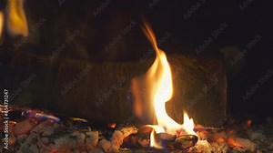 Burning wooden log, camera movement to the right, 4K footage with a burning fire in the fireplace close-up, for a background idea or screensaver about home comfort, real-time video