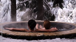couple man and woman relax in a hot spring in nature in winter