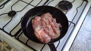 White meat simmering in pan of hot oil. Handheld, rotate, slow motion