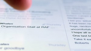 Person scanning a list of emails using a touchscreen portable device