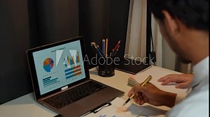Businessman analyzing cost graphs in a conference room with a calculator and laptop with the new project of finance and accounting Presenting ideas and strategic plans at investment meetings.