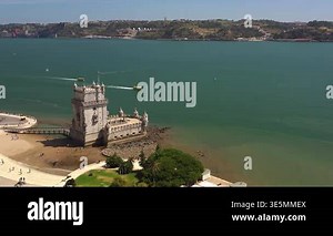 Aerial drone shot of historic Belem Tower standing along Tagus River in Lisbon surrounded by calm blue water, tourists and scenic landscape Stock Video Footage - Alamy