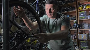 Service engineer performs diagnostics and repairs of bicycle in professional workshop