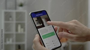 Woman using online booking app to find and book hotel online. Shot on RED film camera.