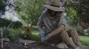 Woman digging and preparing soil for planting in garden / Cedar Hills, Utah, United States