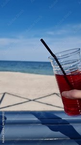 clinking glasses against the background of the sea, two different drinks latte and compote, celebration, relaxation