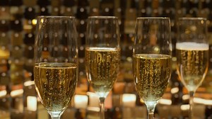 Close up shot of a set of four champagne flute glasses filled with bubbling champagne wine - Free Stock Video