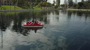 Cute couple enjoying a boat ride in the park.