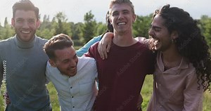 Happy male friends having fun together outdoor - Group of young men hugging each other at park while smiling on camera