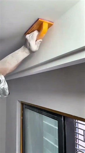Sanding a ceiling and wall surfaces to achieve a perfectly smooth finish before applying final paint