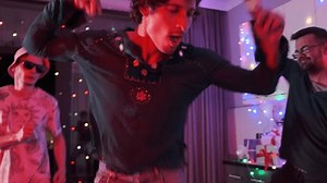 Group of friends line dancing together at home party, dynamic movements of friends getting down dance to beats music in neon lights. Close up.