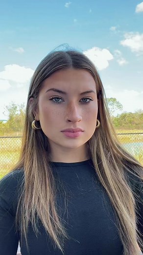 Person Holding a Grey and White Cat Outdoors