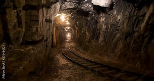 A dimly lit mining shaft. Water dripping onto the rails of the old mining cart.