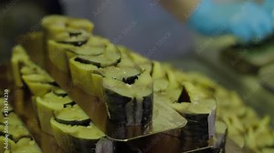 Female worker cutting smoked fish at fish factory. Fish processing plant. Fish of cold hot smoked. Sea food manufacture, fish farm factory, processing fish at food factory