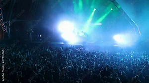 Huge crowd dancing at a DJ show, with great lightning effects