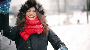 Woman throwing snowball to the camera in the park