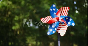Spinning pinwheel with red, white, and blue stars and stripes like the US American flag. Outside fun for USA patriotic holidays like 4th of July, Memorial day, or other patriotic celebrations.