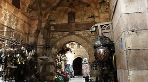 tilt down shot of vendors stalls and ancient stone work at khan el khalili market in cairo, egypt